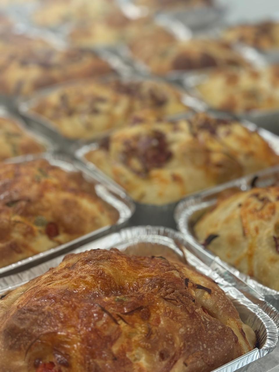 Focaccia artesanal dourada com ervas e azeite, recém-saída do forno